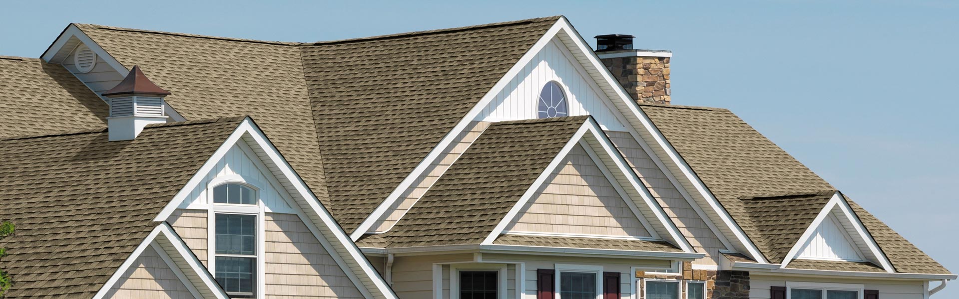 Large mid-class, two-story home with a brown shingle roof